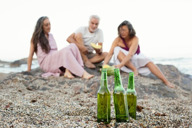 Grupo de amigos senior con cervezas en la playa