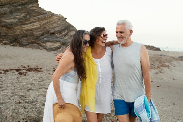 Foto gratuita grupo de amigos senior, pasar tiempo juntos en la playa.