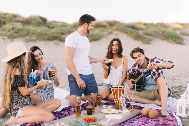 Grupo de amigos sentados en la arena