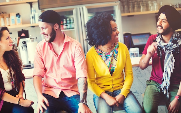 Grupo de amigos sentados y discusión alegre en la cafetería