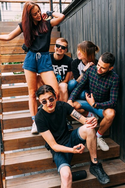 Grupo de amigos sentados en la escalera de madera