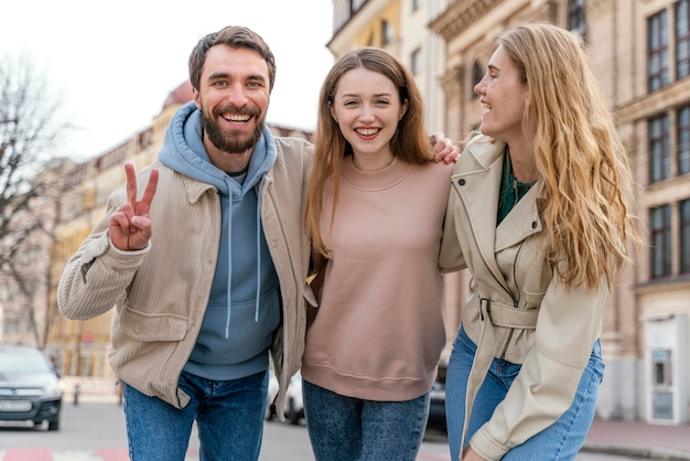 Grupo de amigos sonrientes al aire libre en la ciudad posando