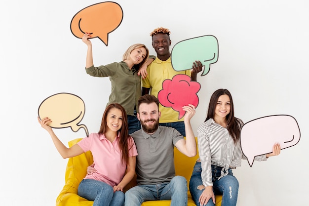 Grupo de amigos sonrientes con burbujas de chat