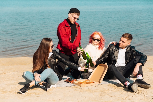 Grupo de amigos sonrientes en picnic en la playa