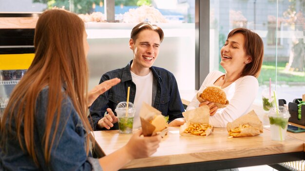 Grupo de amigos sonrientes en el restaurante de comida rápida