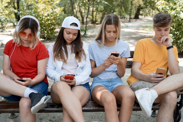 Foto gratuita grupo de amigos de tiro medio en teléfonos