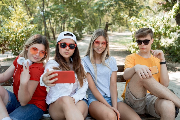 Grupo de amigos de tiro medio tomando selfie