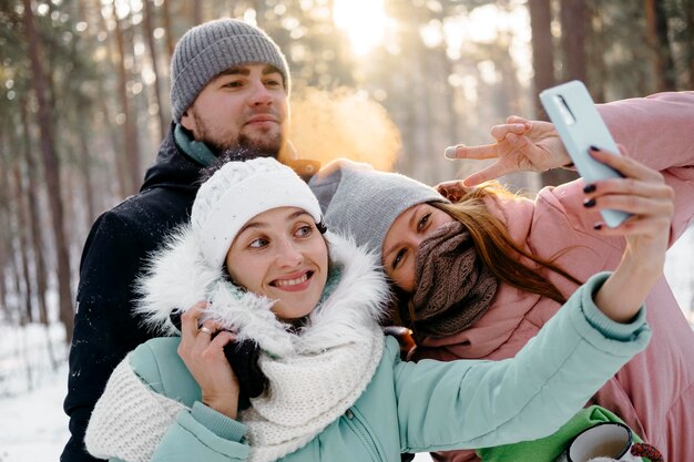 Grupo de amigos tomando selfie al aire libre en invierno