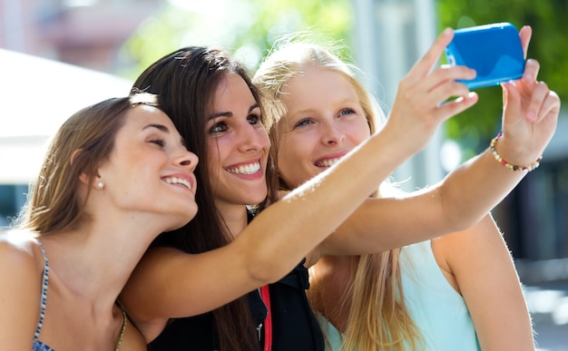 Grupo de amigos tomando selfie en la calle.