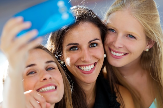 Grupo de amigos tomando selfie en la calle.