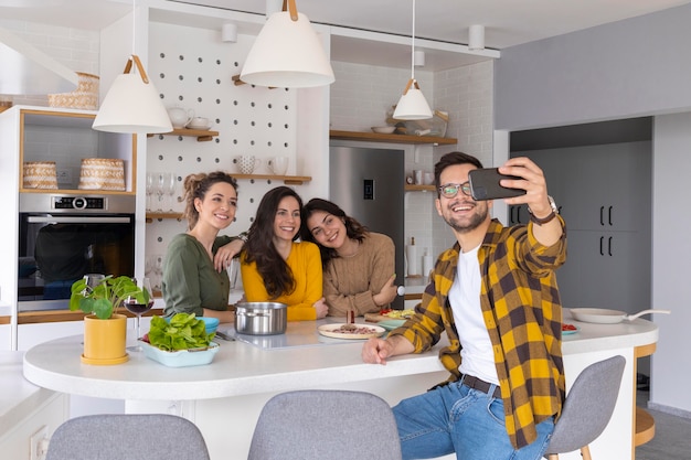 Grupo de amigos tomando un selfie en la cocina