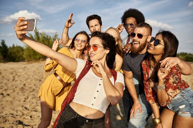 Grupo de amigos tomando un selfie en la playa.