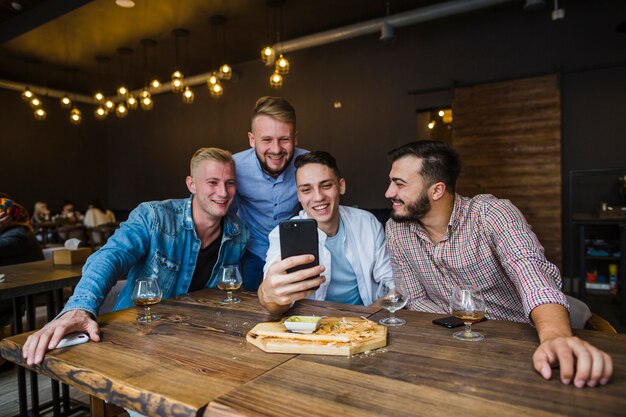 Grupo de amigos tomando selfie en el restaurante