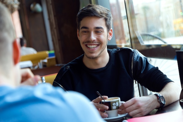 Grupo de amigos usando el teléfono móvil en el café.