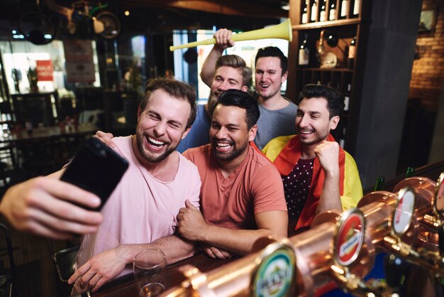 Grupo de amigos varones haciendo un selfie