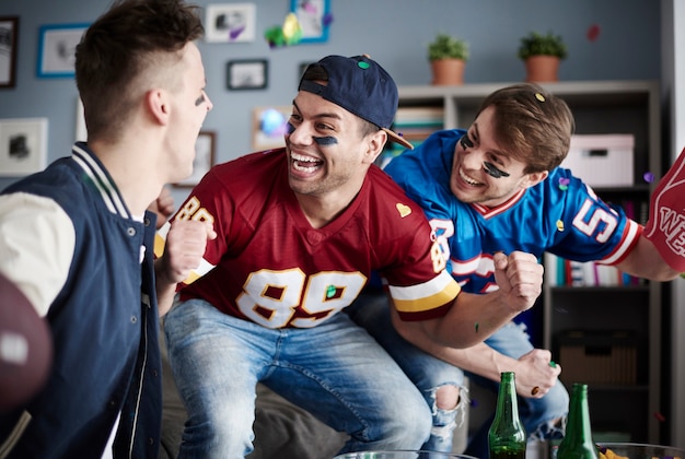 Grupo de amigos viendo fútbol en casa