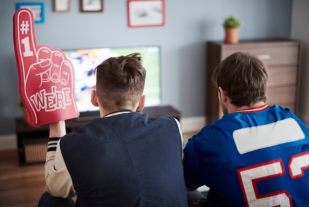 Grupo de amigos viendo fútbol en casa