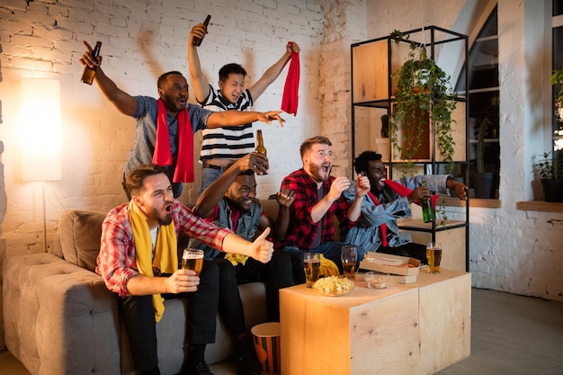 Grupo de amigos viendo la televisión deporte coinciden juntos fanáticos emocionales animando a su equipo favorito viendo el emocionante concepto de juego de amistad actividades de ocio emociones