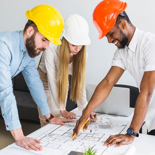 Grupo de arquitecto discutiendo plan de diseño en plano en la oficina