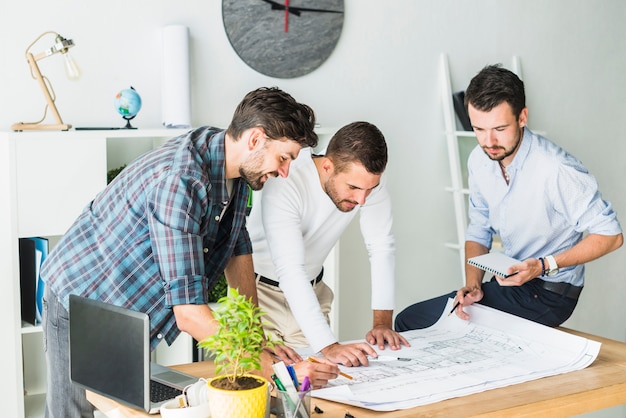 Grupo de arquitecto masculino que prepara el modelo en oficina