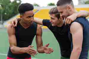 Foto gratuita grupo de atletas multiétnico hablando entre sí en la pista de atletismo