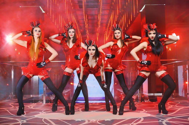 Grupo de bailarinas sexy en trajes rojos a juego realizando