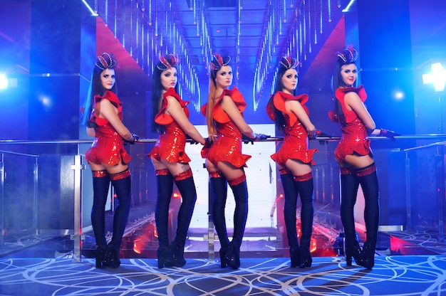 Grupo de bailarinas sexy en trajes rojos a juego realizando