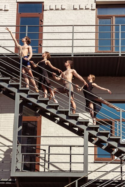 El grupo de bailarines de ballet moderno actuando en las escaleras de la ciudad.