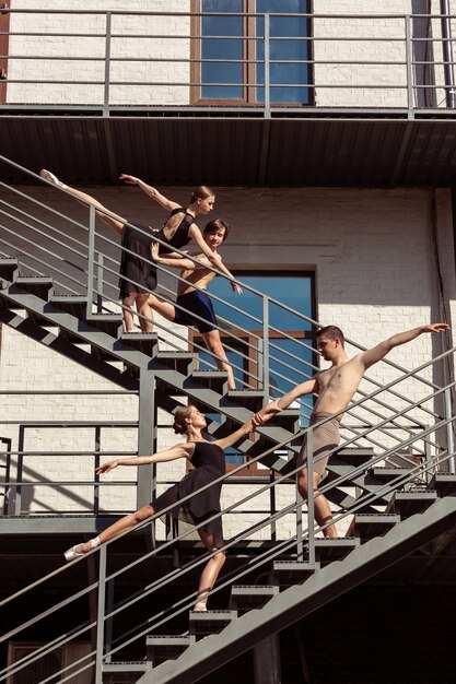 El grupo de bailarines de ballet moderno actuando en las escaleras de la ciudad.