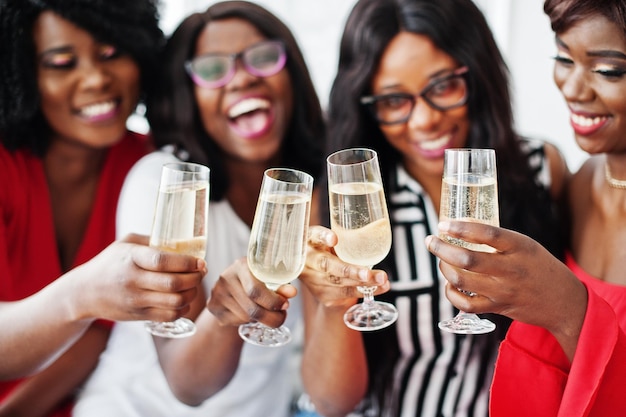 Foto gratuita grupo de chicas africanas de fiesta tintineando copas con champán de vino espumoso