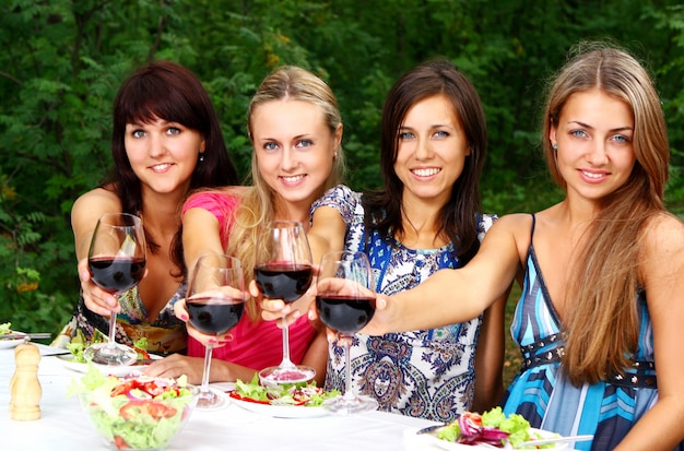 Grupo de chicas jóvenes bebiendo vino en el parque