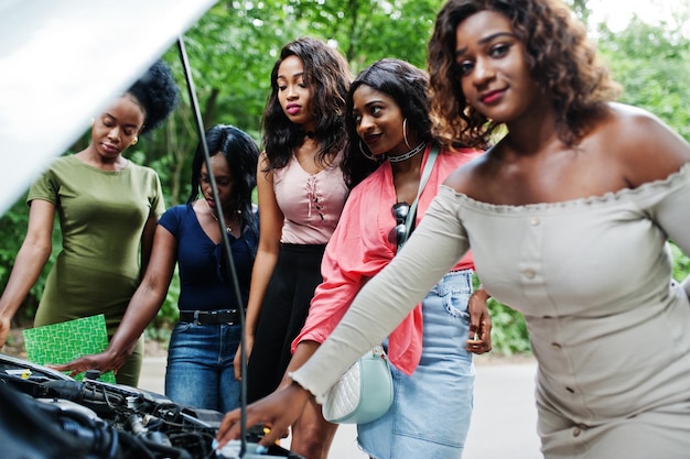 Foto gratuita grupo de cinco chicas viajeras afroamericanas mirando el capó abierto del coche roto