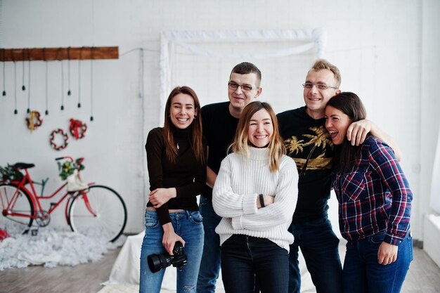 Grupo de cinco pueblos amigos fotógrafos y diseñadores en estudio de fotografía después de un duro día de trabajo Están felices y riendo