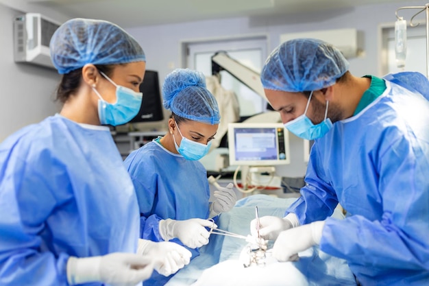 Grupo de cirujanos que realizan cirugía en el quirófano del hospital Equipo médico que realiza una operación crítica Grupo de cirujanos en quirófano con equipo de cirugía Antecedentes médicos modernos