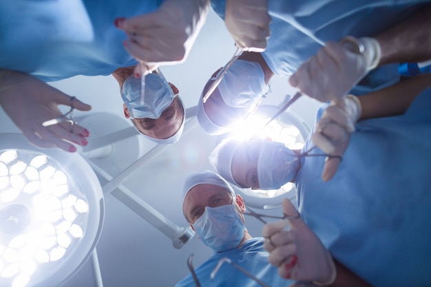 Grupo de cirujanos realizando operaciones en quirófano