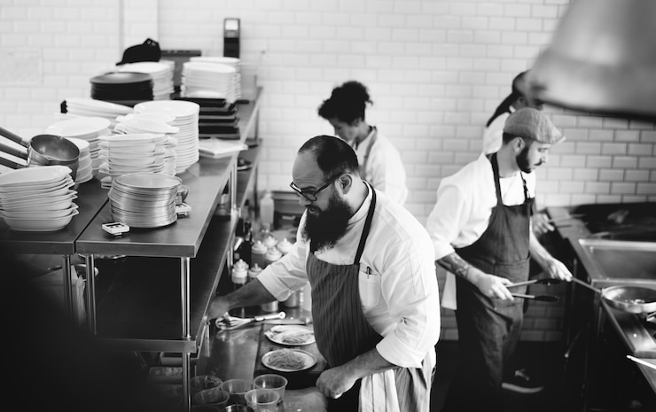 Foto gratuito grupo de cocineros que trabajan en la cocina.