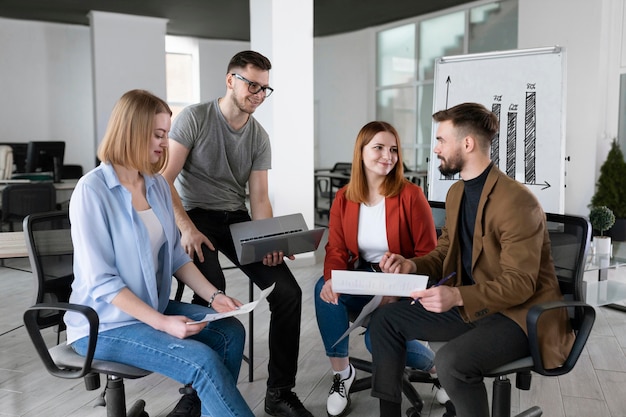 Grupo de compañeros de trabajo en la oficina hablando