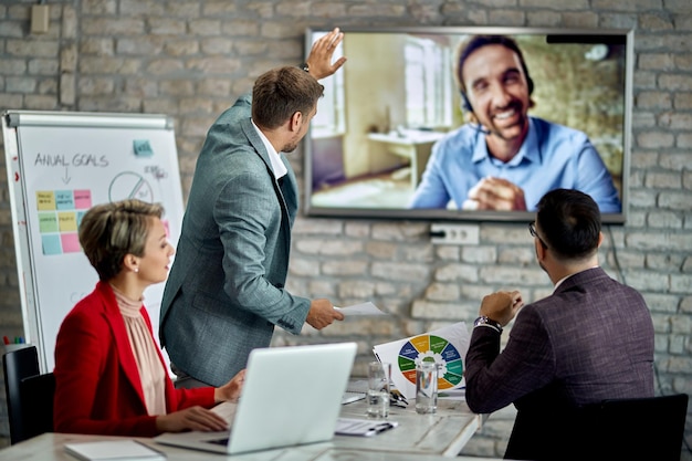 Foto gratuita grupo de compañeros de trabajo que tienen videoconferencia de negocios mientras trabajan en la oficina