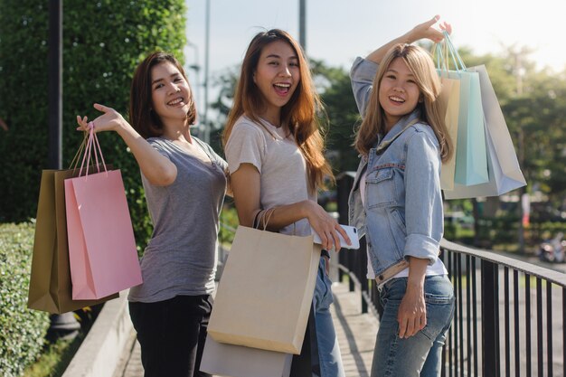 Grupo de compras asiáticas jovenes de la mujer en un mercado al aire libre con los panieres en sus manos