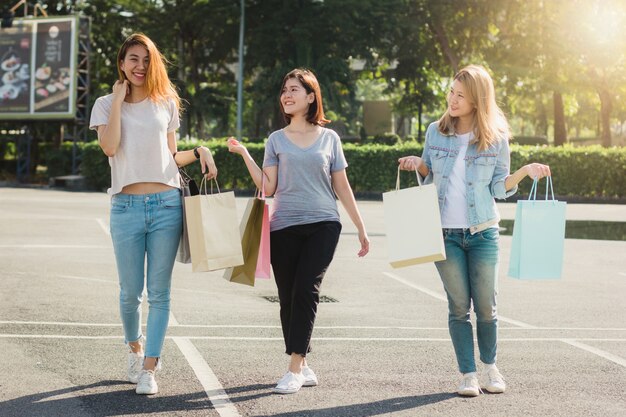 Grupo de compras asiáticas jovenes de la mujer en un mercado al aire libre con los panieres en sus manos