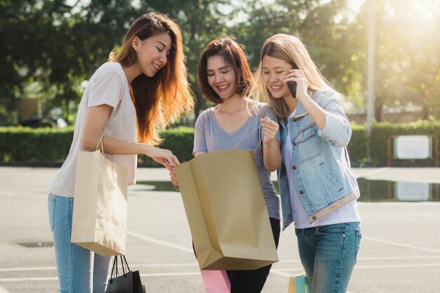 Grupo de compras asiáticas jovenes de la mujer en un mercado al aire libre con los panieres en sus manos