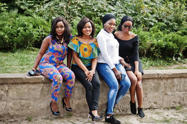 Grupo de cuatro chicas afroamericanas sentadas al aire libre