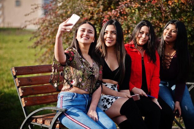 Grupo de cuatro chicas latinas felices y bonitas de Ecuador posaron en la calle y se hicieron selfie por teléfono