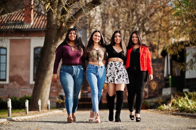 Grupo de cuatro chicas latinas felices y bonitas de Ecuador posaron en la calle