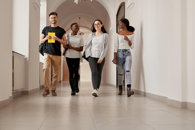 Grupo de cuatro estudiantes multirraciales que pasan tiempo juntos