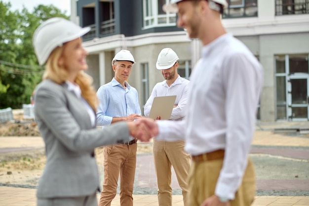 Grupo de cuatro personas de pie en el sitio de construcción