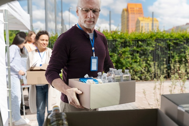 Grupo de diferentes personas voluntarias en un banco de alimentos para personas pobres