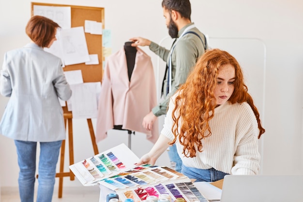 Grupo de diseñador de moda que trabaja en atelier con paleta de colores y forma de vestido