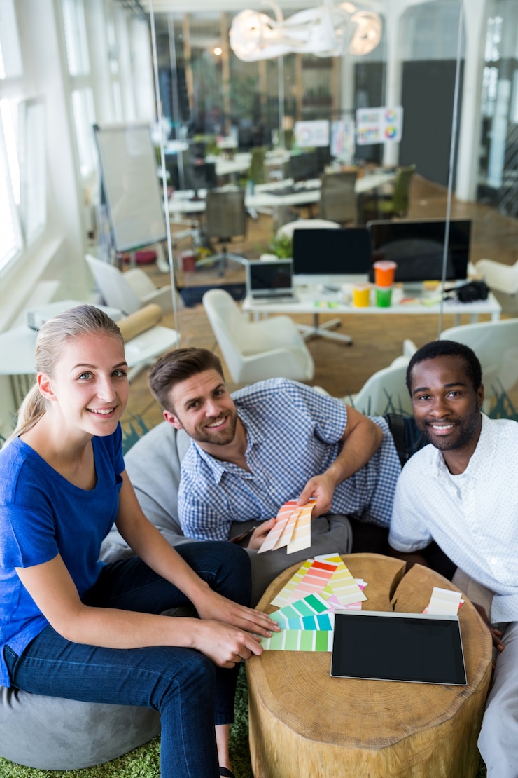 Foto gratuito grupo de diseñadores gráficos sonriendo y sentados juntos