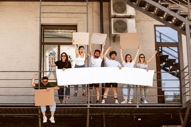 Grupo diverso de personas protestando con carteles en blanco. Protesta contra los derechos humanos, abuso de libertad, problemas sociales.